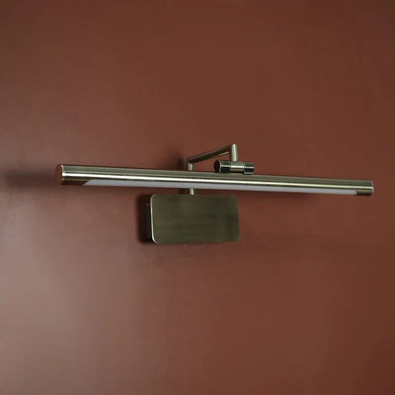 A modern wall-mounted light fixture with a long horizontal brushed metal bar, a rectangular backplate, and a small side adjustment knob, shown against a warm reddish-brown wall.