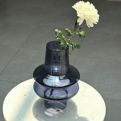Unique black ripple Glass Vase with a white flower on a reflective surface