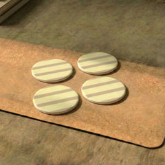 Four round Rayè Coasters made of metal with striped pattern on a wooden surface