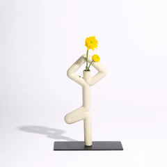 Modern white Vrikhasana Ceramic Vase shaped like a person with yellow flowers on a light gray background
