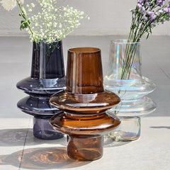 Collection of glass Ripple Glass Vases with flowers on a light gray surface