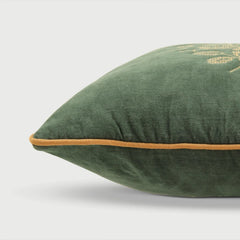 Green pillow with a brown border on a light gray background