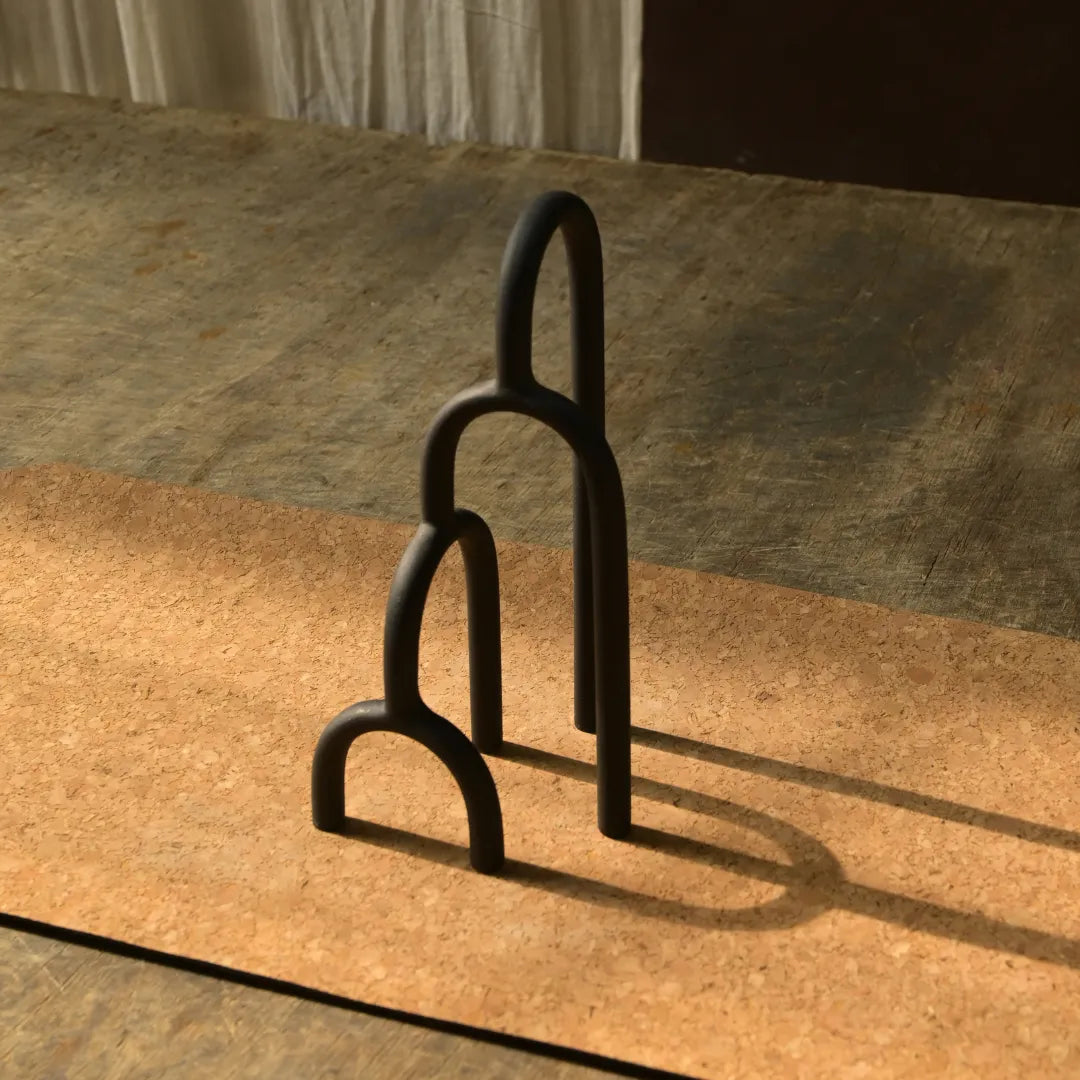 Aria Decor Sculpture, Two black metal horse stirrups on a stone surface