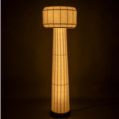Domus Floor Lamp with a cylindrical design and textured surface, illuminated showing warm ambient glow
