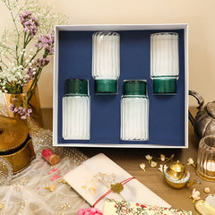 A set of four highball glasses with a striped design, displayed in a gift box with a blue background. The glasses base is in green color.