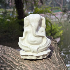 White hand painted Ganesha Abstract Sculpture of a seated figure on a tree stump with a natural background
