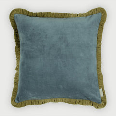 A square throw pillow featuring a dusty blue velvet center panel and an olive green ruffled border, shown against a plain light gray background.