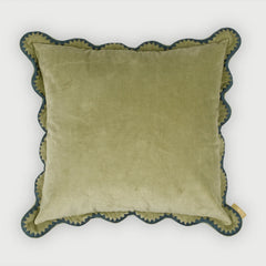 Green cushion with scalloped edge on a white background