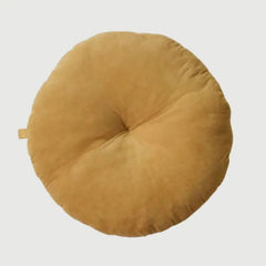 A round, low-profile floor cushion in a warm camel tan color, photographed from directly above on a light gray background.