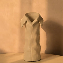 Beige ceramic vase with collar rim and hand-textured surface on a beige background