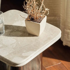Ruvy Side Table - Close-Up of Rounded Beige Marble Corner with Potted Plant
