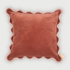 Brown pillow with pink trim on a light gray background