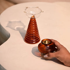 Composite Gift Box, hand placing kalash oil lamp beside ribbed amber tall diya, top view