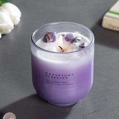 Amethyst & Citrine Candles - Crystal Energy - Set of 2, lit violet candle with amethyst chips on dark surface