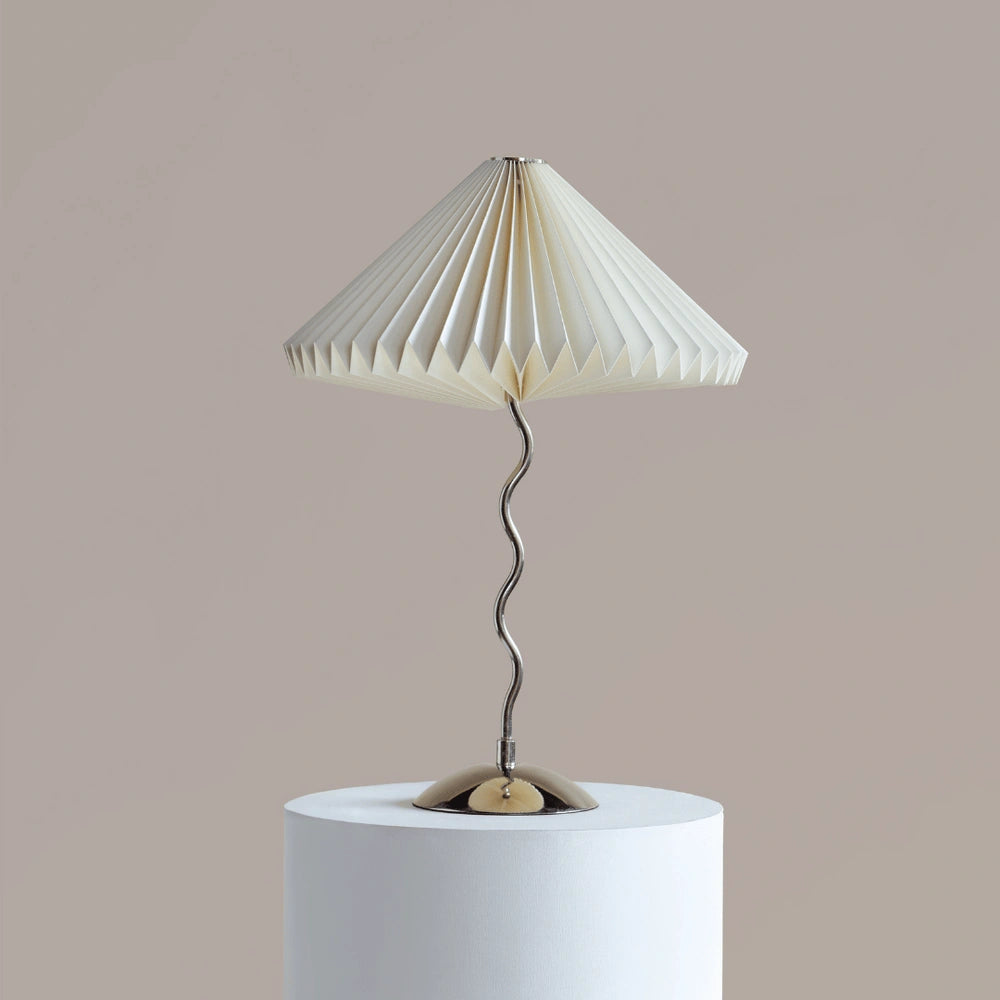 Wavy Table Lamp with pleated white shade on a cylindrical base against a beige background