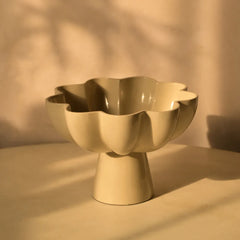 Beige metal bowl with a unique design on a beige background