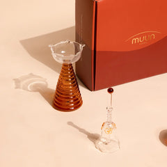Composite Gift Box, tall diya and glass bell with amber bead top beside orange Muun box