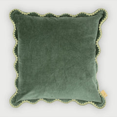 Green velvet pillow with scalloped edge on a white background