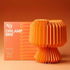 An orange origami paper table lamp shaped like a mushroom, displayed next to its orange packaging box with the text 'fig ORILAMP MINI'.
