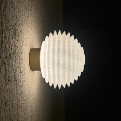 Modern Skive wall light on a textured wall with a dark background