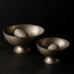 Two metallic arc bowls with sliver finish and scalloped edges on a black background