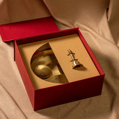 Gold decorative Pooja Brass Thali & Bell used for the dawn rituals in a red box on a beige fabric background