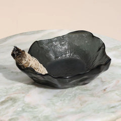 Ash Grey color glass bowl with a rolled sage on a marble surface