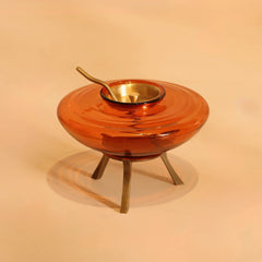 Muun Ghee Daani on three-legged metal base with brass lid and curved spoon, brass-antique finish, front view