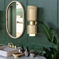 Metamorphosis Wall Lamp installed beside mirror in bathroom or vanity, ambient wall light blending craft and minimalism.