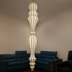 Decorative pendant light hanging in a room with dark blue sofas.