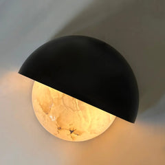 Black wall-mounted light fixture with a warm ambient glow 