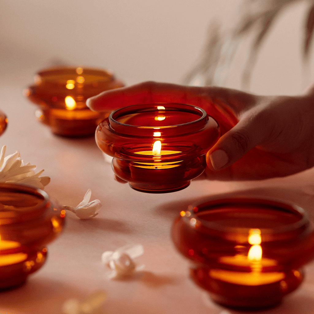 Amber glass diya-shaped candle holder with gentle glow