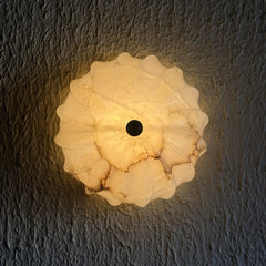 Spiral Alabaster wall lamp with textured white design on a dark textured wall