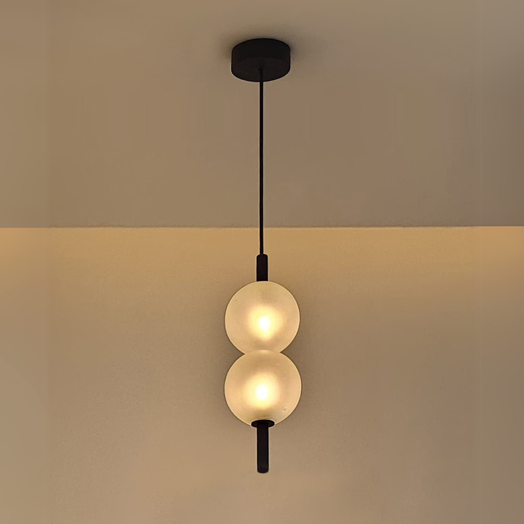 Modern pendant light with two round glass shades to create ambient light and visual calm