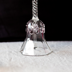 Decorative Ringing Glass Bell with floral patterns on a textured surface