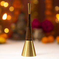 Decorative puja bell with wooden and brass finish against a blurred festive background