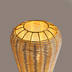 Wicker Meiji Table Lamp with a warm glow on a gray background