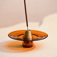 Incense Holder - Amber with a single incense stick on a light background