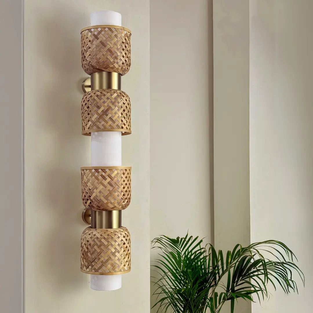 Designer wall sconce with woven design on a neutral wall with a plant in the corner.