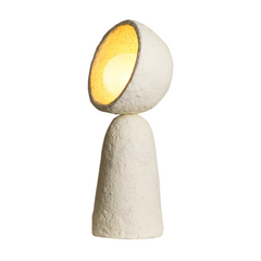 Side look of a handcrafted Echo Sphere Table Lamp made from paper mache, with a textured, beige surface and a round top, casting a warm glow.