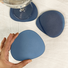 Blue Frosted Glass Coasters Set of 4, placed on a table with glass of water
