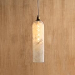 Pendant light with a textured glass shade on a wooden background