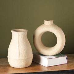 Two different design ceramic vases on a wooden surface.