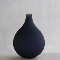 Decorative dhara black vase made of glass with textured design.