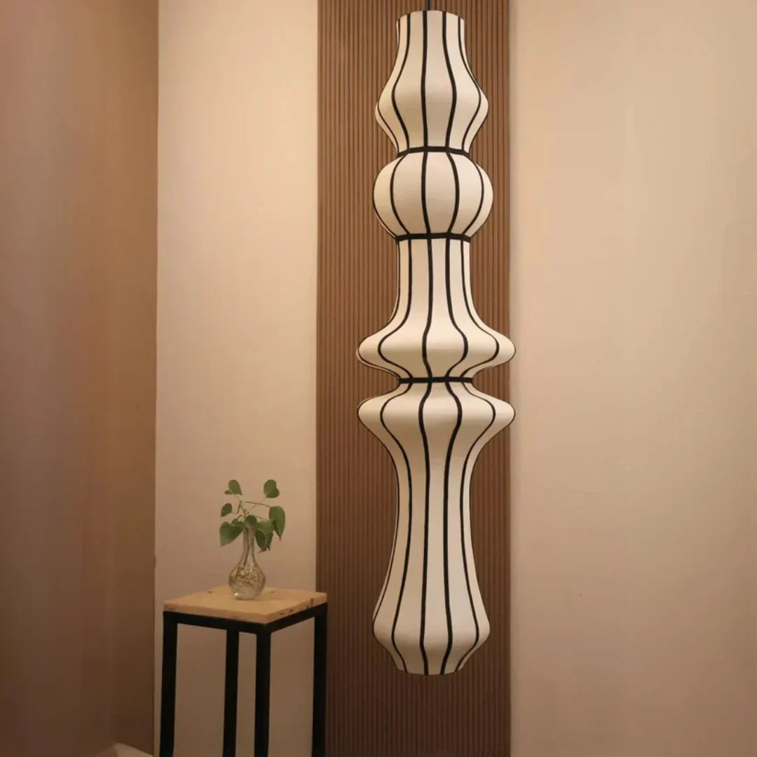 Decorative wall-mounted pendant lamp with a unique design against a beige wall.