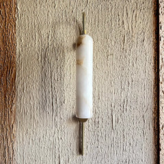 Lune Rise Alabaster Wall Light with white cylindrical shade and brass accents on a textured wall.