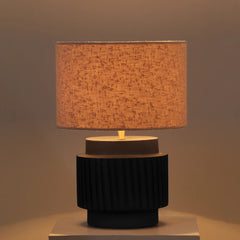 Round Albe Table Lamp with a textured brown shade and black terracotta base on a neutral background