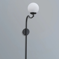 Glamour Arch Wall Lamp with a white glass globe shade and black curved arm on a gray background