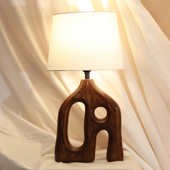 Unique style Orion Table lamp with wooden base and white shade on a beige fabric background