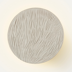 Clay disc wall lamp casting soft ambient light